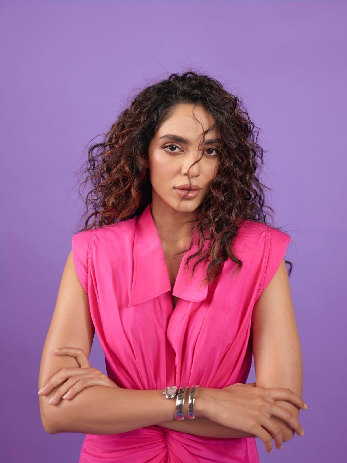 &nbsp;Her cascading curls, carefully styled, add an element of allure to her overall appearance.